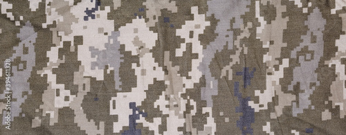 Slightly crumpled fabric with digital camouflage pattern. Panoramic view, background