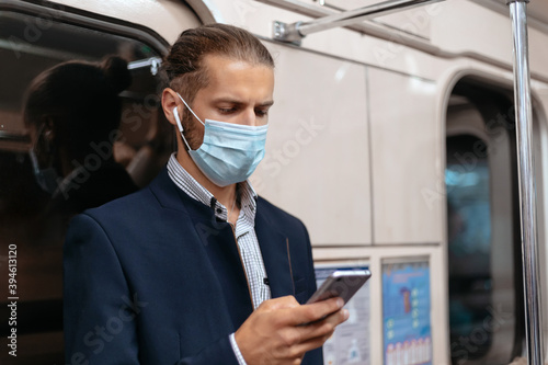 man in a protective mask reading an email.