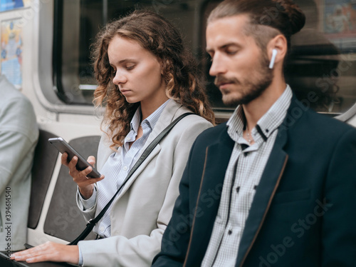 passengers with smartphones sitting in a subway car . © yurolaitsalbert