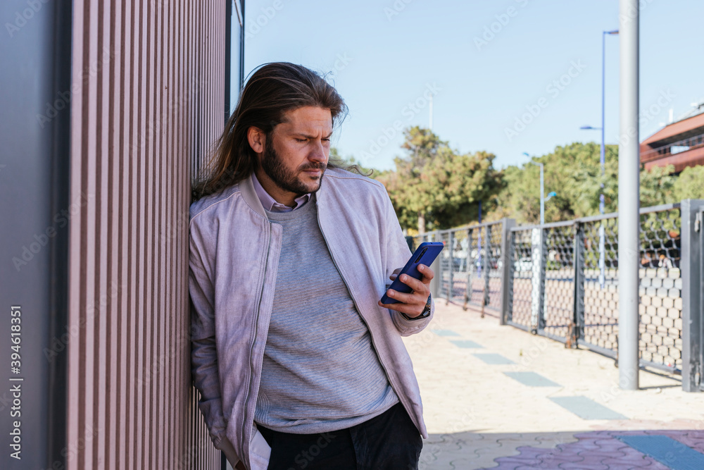 man leaning on the wall with mobile