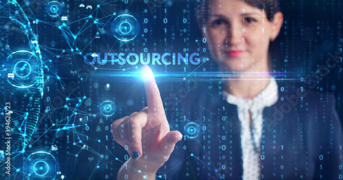 Business, Technology, Internet and network concept. Young businessman working on a virtual screen of the future and sees the inscription: Outsourcing