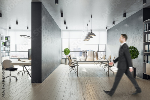 Businessman walking in contemporary coworking office in a loft style interior © Who is Danny