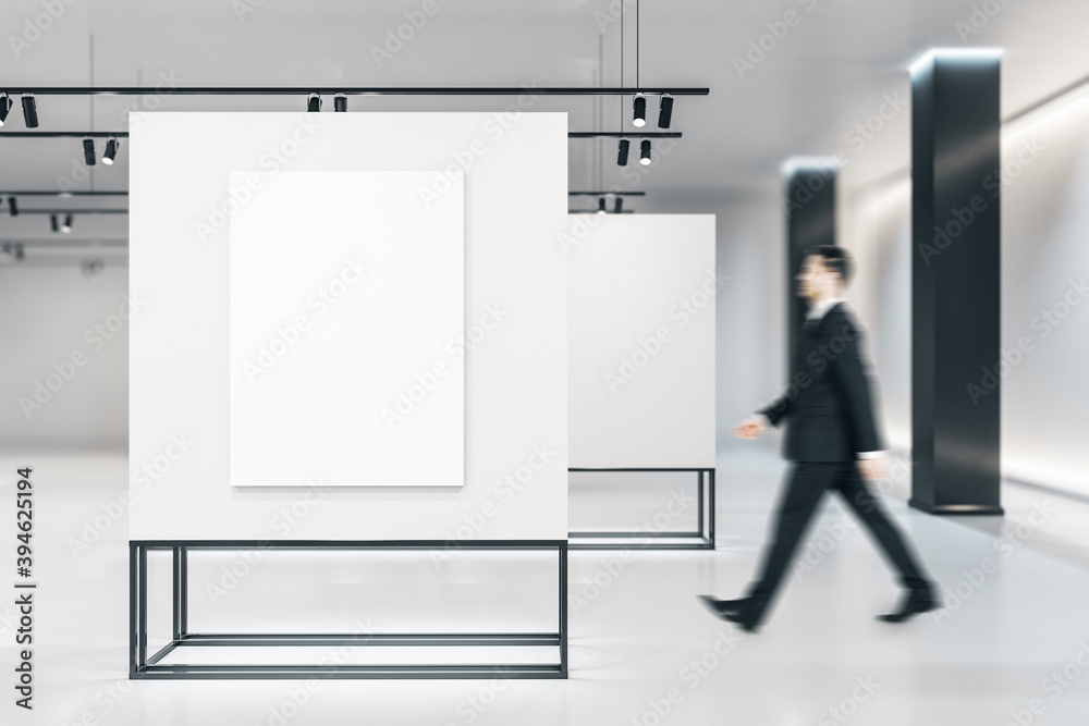 Businessman in modern gallery interior with empty banner Businessman in modern gallery interior with empty banner