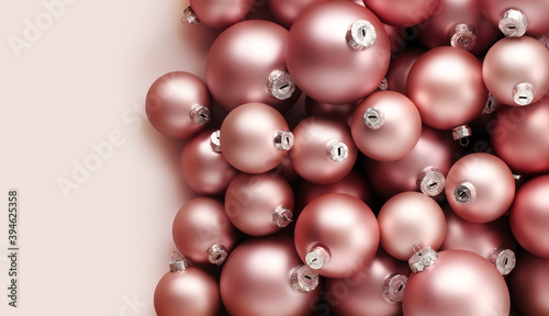 Christmas decorations, top view of pile of glass balls colored in blush pink, isolated on pink background, useful as a greeting gift card template