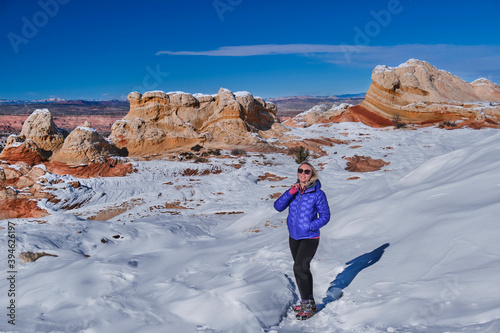 Woman walking on snow in colorful canyon. Vermillion Cliffs National Monument. Arizona. USA 