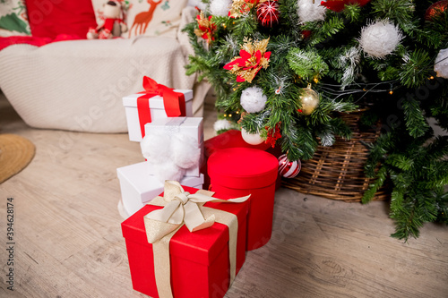 Christmas gift boxes and shopping package newr Chrismas tree on wooden floor.Holiday morning. New year present paper package. Festive mood. celebration concept,gift boxes photo