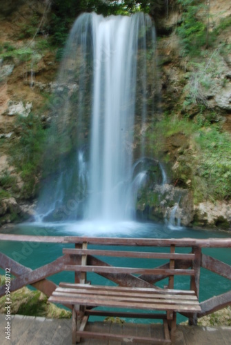 Fototapeta Naklejka Na Ścianę i Meble -  a bench in front of a large waterfall