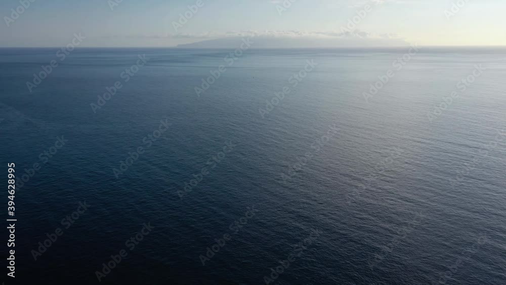 Flying over the blue surface of the sea or ocean