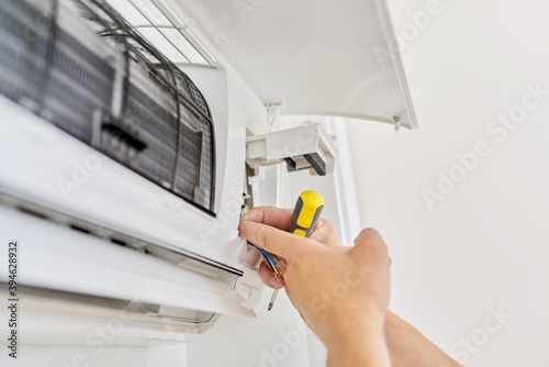 Installing an air conditioner in an apartment office, close-up of an engineer hand photo