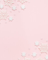 Christmas or winter composition. Frame made of snowflakes on pastel pink background. Christmas, winter, new year concept. Flat lay, top view, copy space
