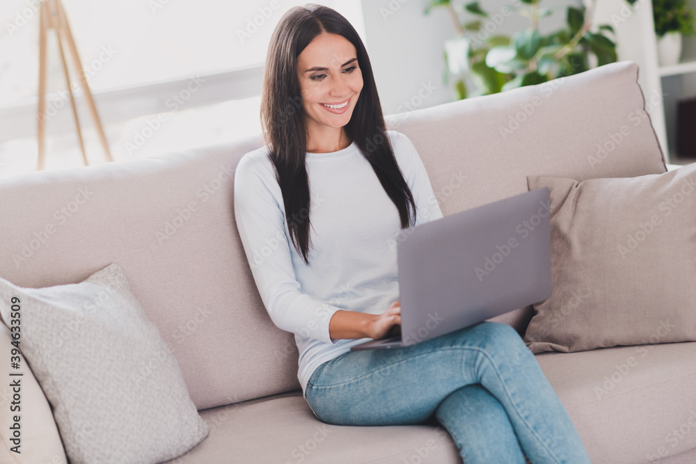 Photo of positive happy woman chatting on laptop sit couch weekend at home free time inside house indoors Photo of positive happy woman chatting on laptop sit couch weekend at home free time inside house indoors