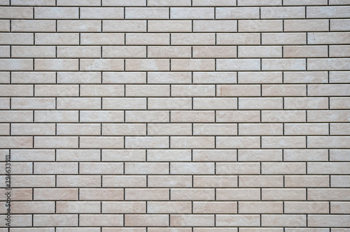 Textured white and brown brick wall with stone texture and gray seams. decorative tiles for wall decoration. Artificial stone. Background, texture