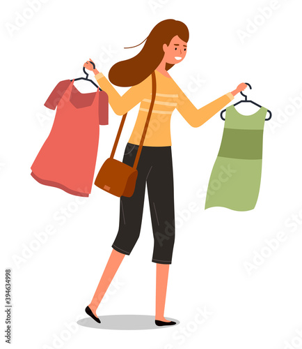 The girl with a hangers with t-shirts in her hands goes shopping. Buyer is selecting clothes in a store. Young beautiful fashion girl isolated on white background. Shopper during the sale in a store