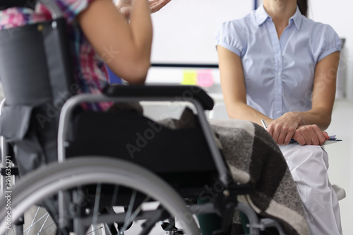 Woman in a wheelchair in consultation with psychologist. Psychological assistance to people with disabilities concept