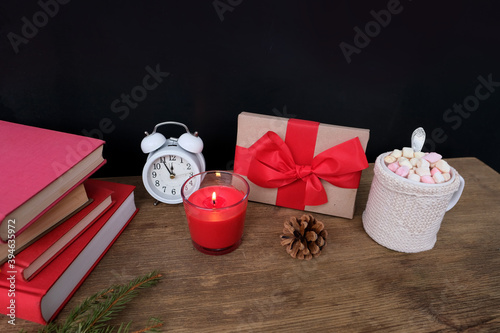 Fototapeta Naklejka Na Ścianę i Meble -  warm colored sweaters, a cup of hot cocoa with marshmallows, candles, gifts, sweets, the concept of merry christmas, cozy winter mood, holiday