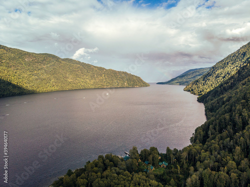 Drone view of a long wide river around which a flattering area. Lots of trees and jungle. Unity with nature