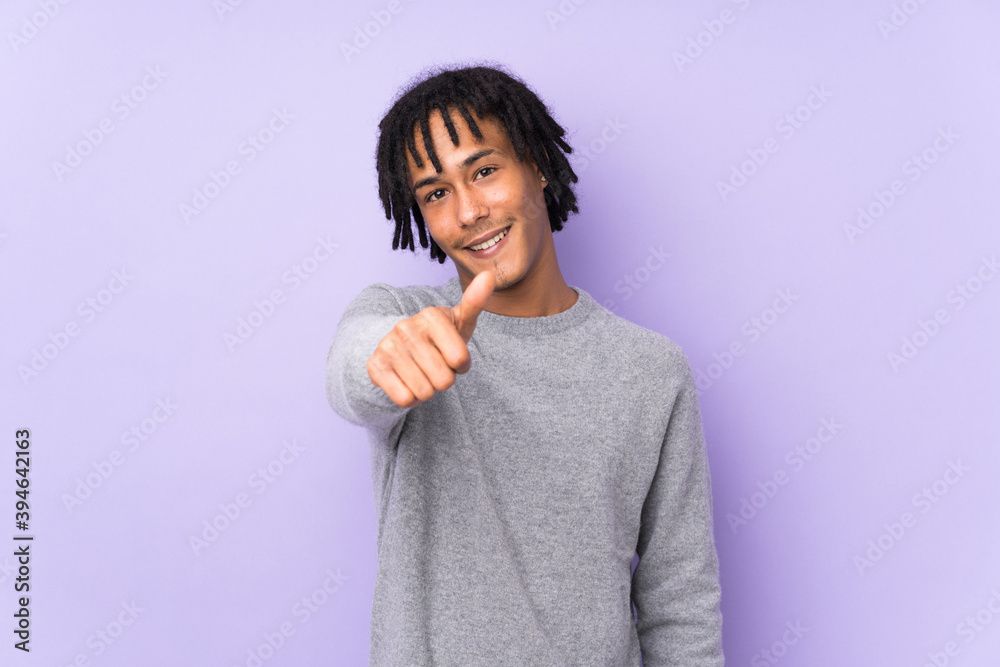 Young african american man isolated on purple background with thumbs up because something good has happened