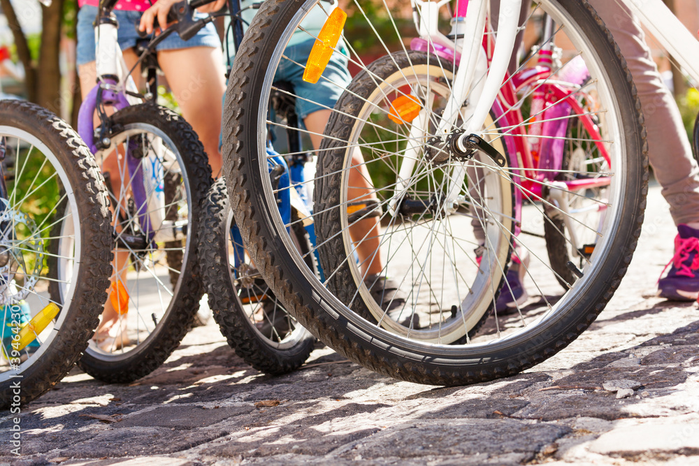 Close-up picture of kids bicycles standing on the cobblestone paved road Close-up picture of kids bicycles standing on the cobblestone paved road