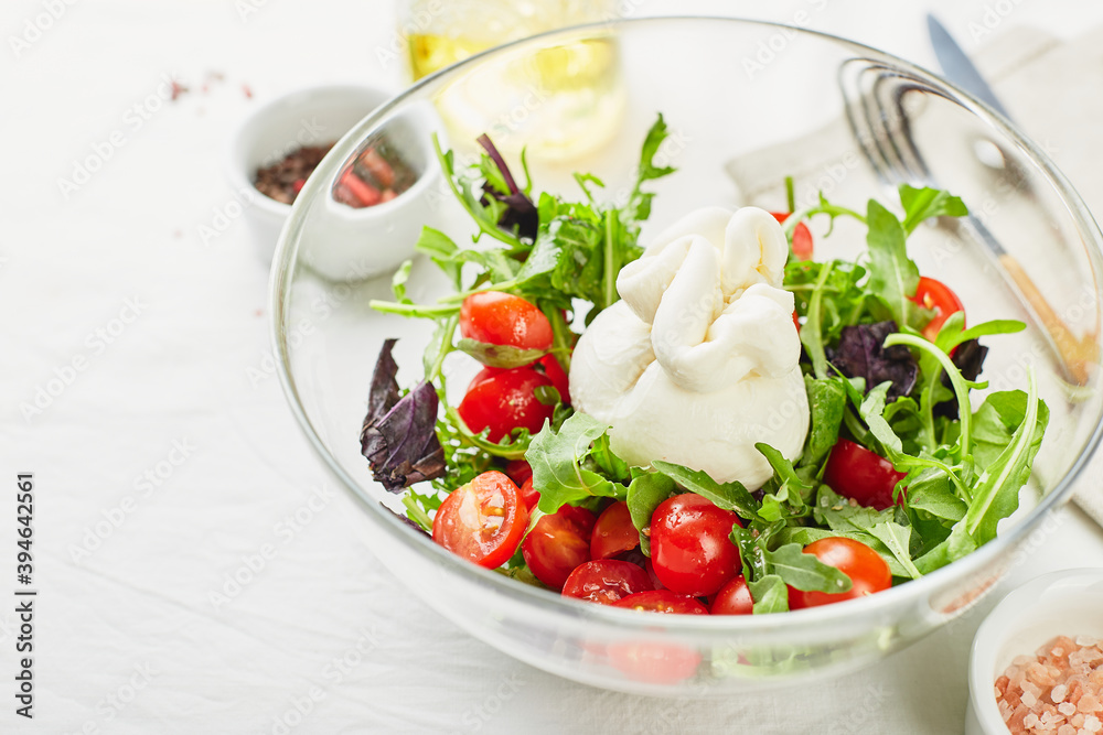 Burrata, Italian fresh cheese made from cream and buffalo or cow milk, with tomato, arugula and red basil salad Burrata, Italian fresh cheese made from cream and buffalo or cow milk, with tomato, arugula and red basil salad