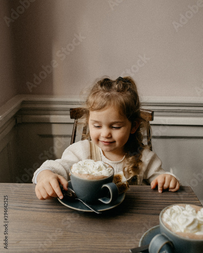 Little girl with a big cup of hot chocolate