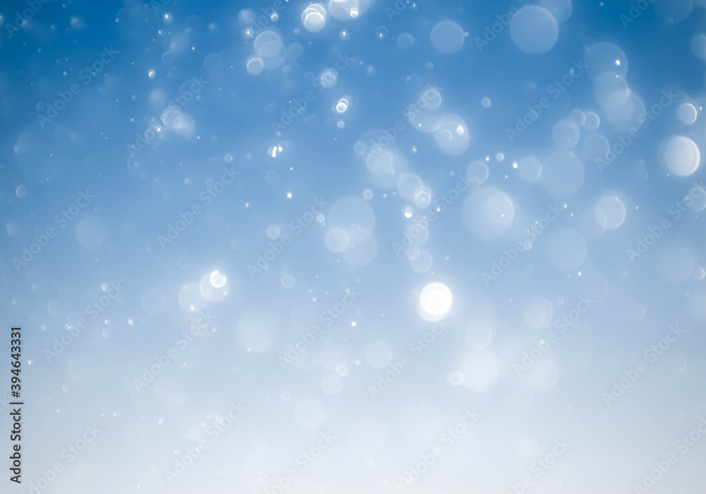 Winter snowfall and snowflakes on light blue background.blue bokeh abstract light backgrounds