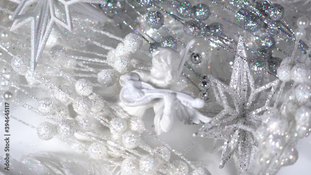 Woman takes different sparkling and shiny Christmas decor from white background. Woman takes different sparkling and shiny Christmas decor from white background.