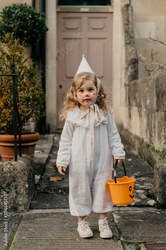Small child dressed up in costume in front of a house door