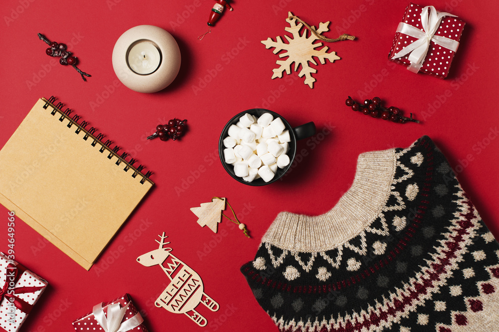 Fashion flat lay knolling with cozy sweater and gift box on red background Fashion flat lay knolling with cozy sweater and gift box on red background