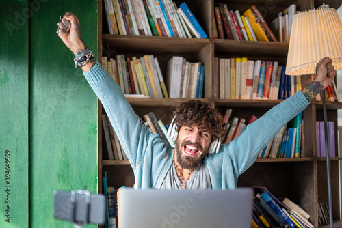 influencer with beard and tattoos rejoices in front of his followers, connections through modern technology, internet, music, social networks, new jobs as bloggers and multimedia content creators