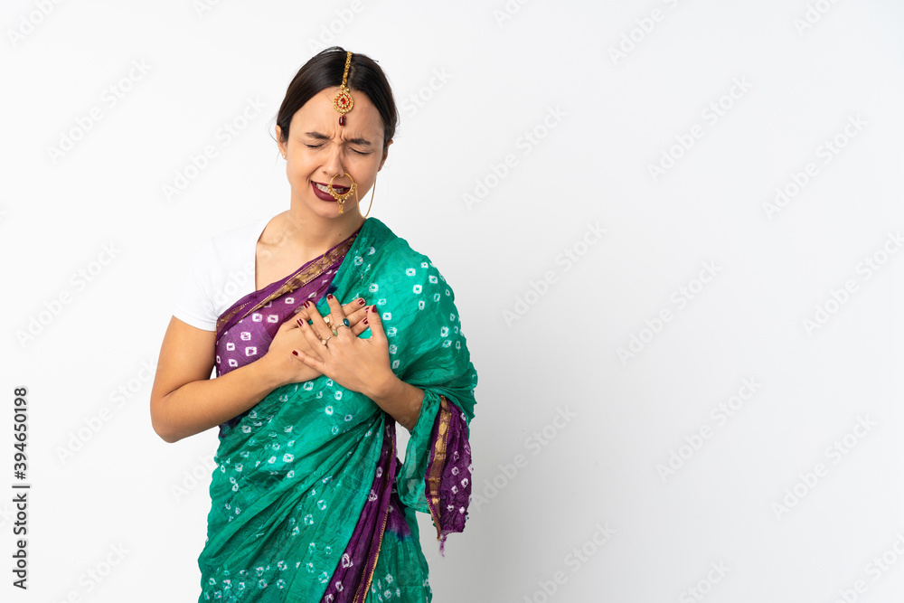 Young indian woman isolated on white background having a pain in the heart