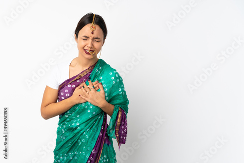 Young indian woman isolated on white background having a pain in the heart