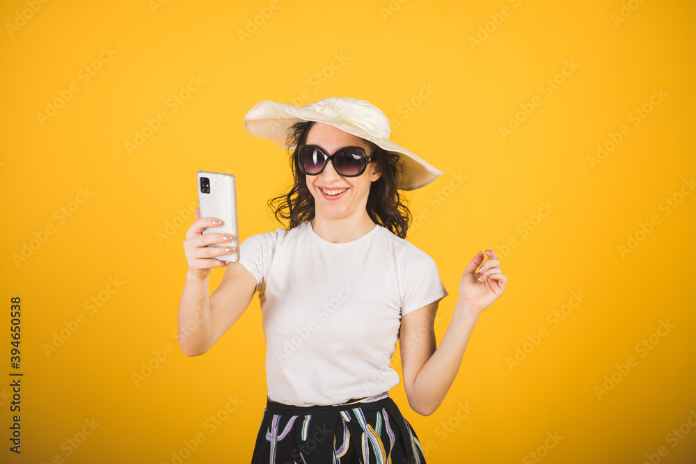 Stylish beautiful girl portrait on a yellow background with a phone Stylish beautiful girl portrait on a yellow background with a phone