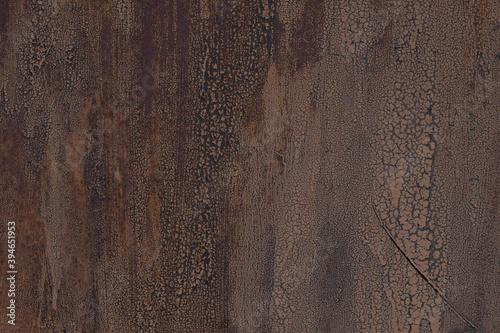 Grunge brown metal wall with peeling paint, close-up background photo texture