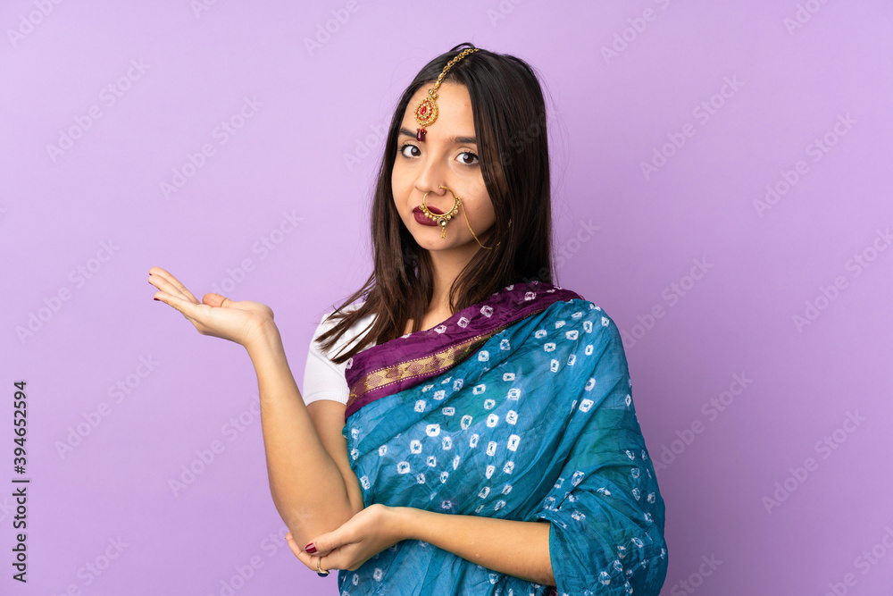 Young Indian woman isolated on purple background having doubts Young Indian woman isolated on purple background having doubts