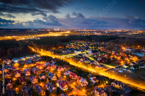 Aerial landscape of illuminated streets of small town in Poland at dusk.