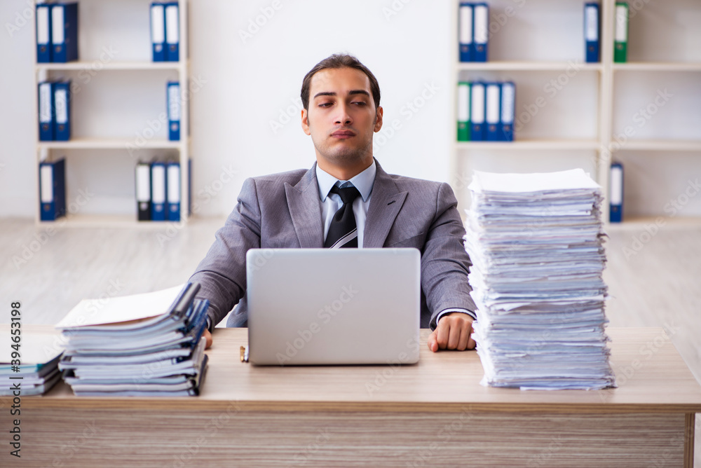 Young male employee unhappy with excessive work Young male employee unhappy with excessive work