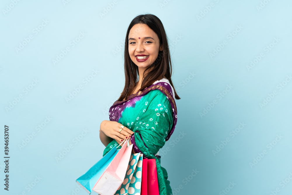 Young Indian woman with shopping bags with arms crossed and looking forward Young Indian woman with shopping bags with arms crossed and looking forward