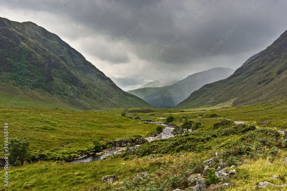 Glen Etive, a remote valley in the mountains near Glencoe in the Highlands of Scotland, where the River Etive flows between banks lined with heather and bracken.
