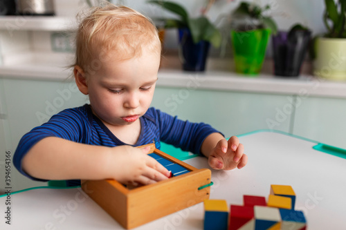Baby playing with wooden blocks creating a pattern