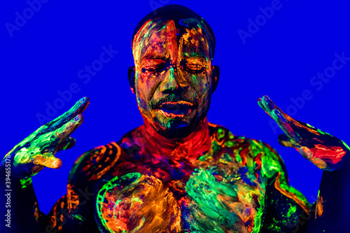 afro american man with UV body art posing in studio