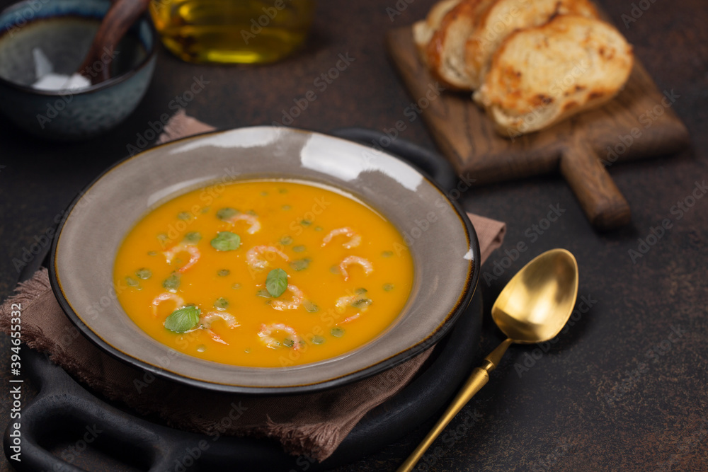 Pumpkin soup with shrimps and basil oil with toasted bread. Copy space. Pumpkin soup with shrimps and basil oil with toasted bread. Copy space.
