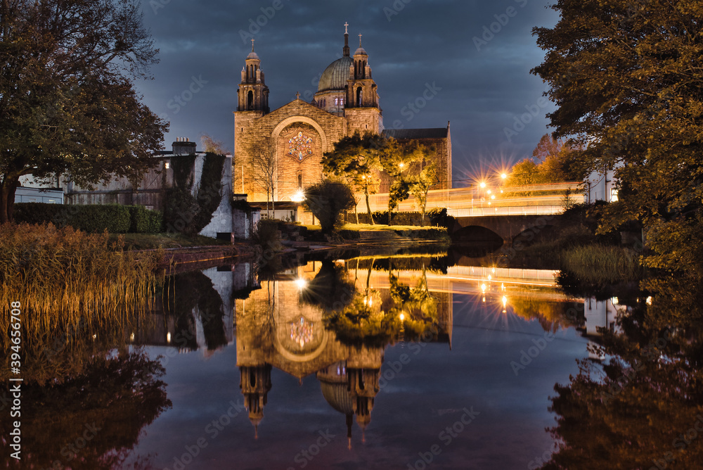 Obraz premium Galway cathedral by the Corrib River at night with reflection in water in Ireland