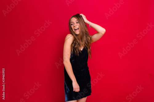 Glamorous young woman dancing and holding hair. Wonderful curly female model preparing for new year party, christmas mood