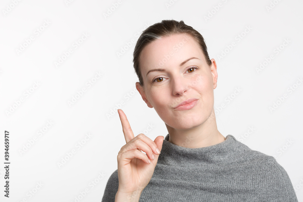 young woman rises her trigger finger and grimaces and looks as if she knows young woman rises her trigger finger and grimaces and looks as if she knows