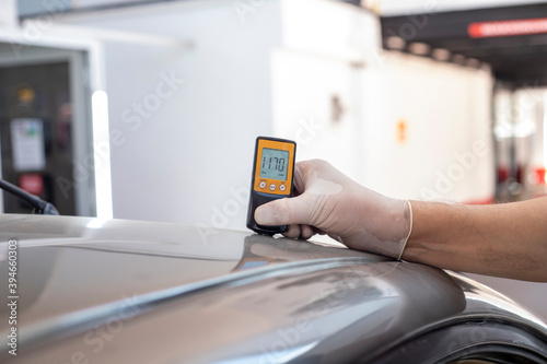 Checking the thickness of car paint using an electronic sensor photo