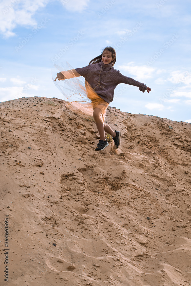 Preteen girl running with joy from sand hill and smiling Preteen girl running with joy from sand hill and smiling