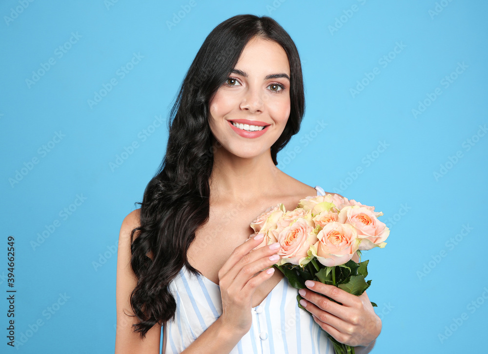 Portrait of smiling woman with beautiful bouquet on light blue background Portrait of smiling woman with beautiful bouquet on light blue background