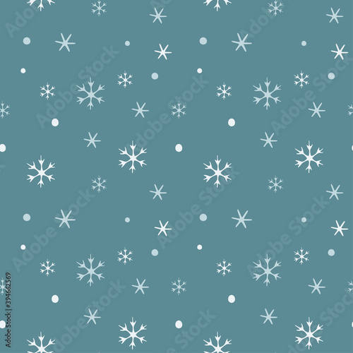 Seamless pattern with falling snowflakes on a blue background