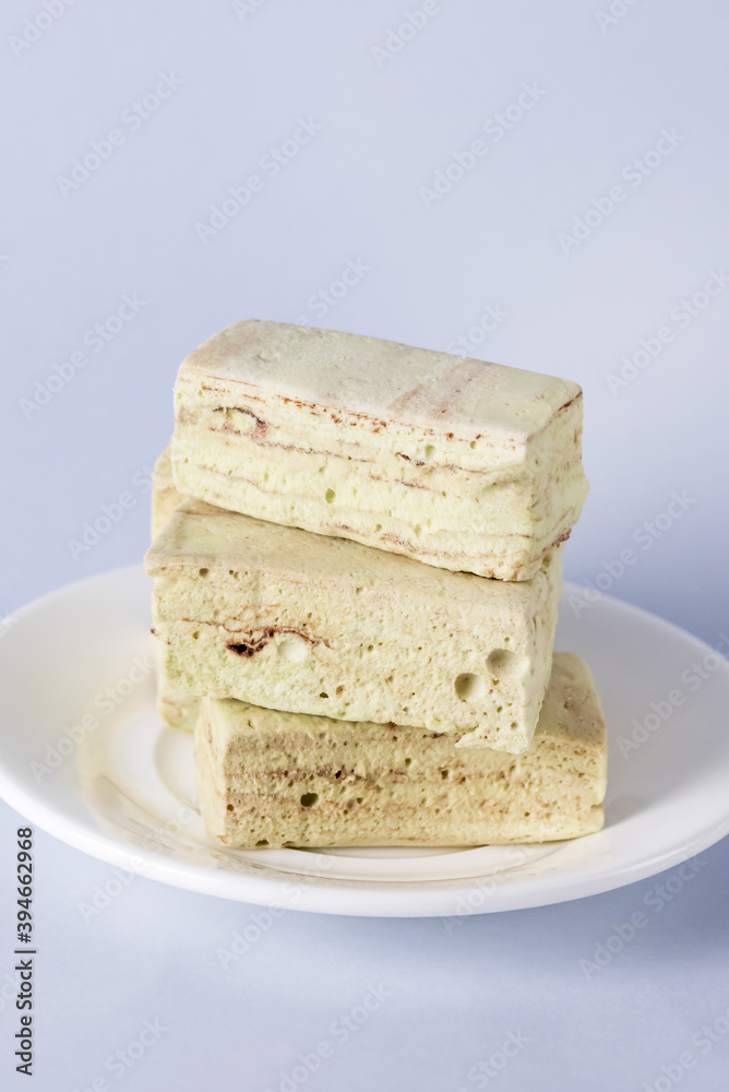 White Plate with Homemade Tasty Marshmallows with Mint and Chocolate Blue Background Vertical