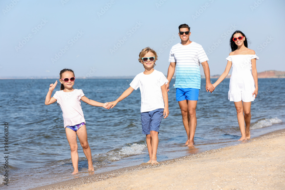 Happy family walking on sandy beach near sea. Summer holidays Happy family walking on sandy beach near sea. Summer holidays